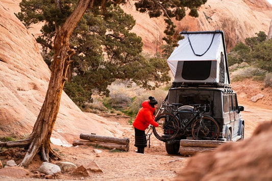 Camper setting up roof top tent